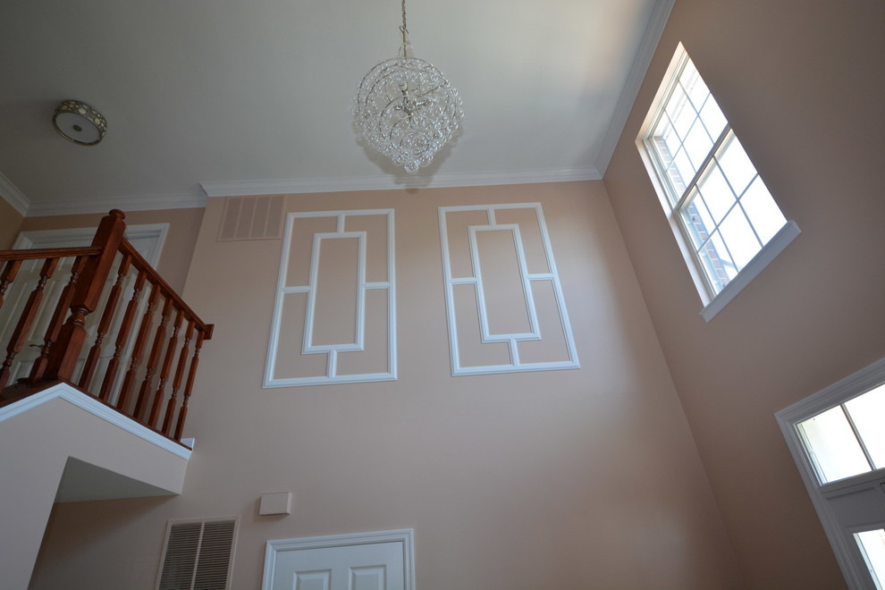 Example of a large transitional dark wood floor foyer design in Baltimore with orange walls and a white front door