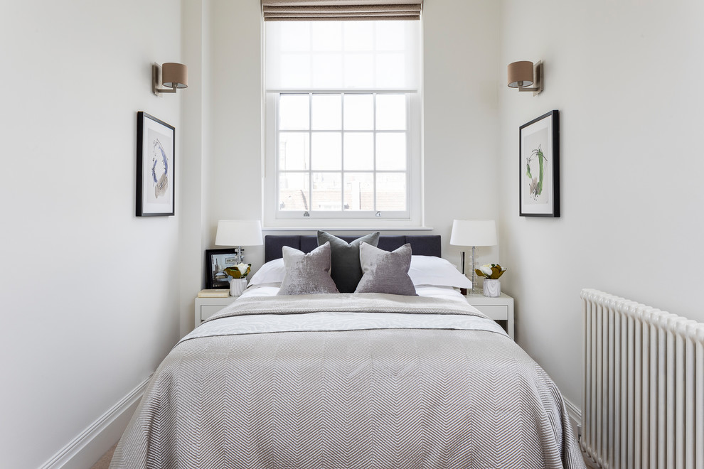 Photo of a small transitional guest bedroom in London with white walls and no fireplace.