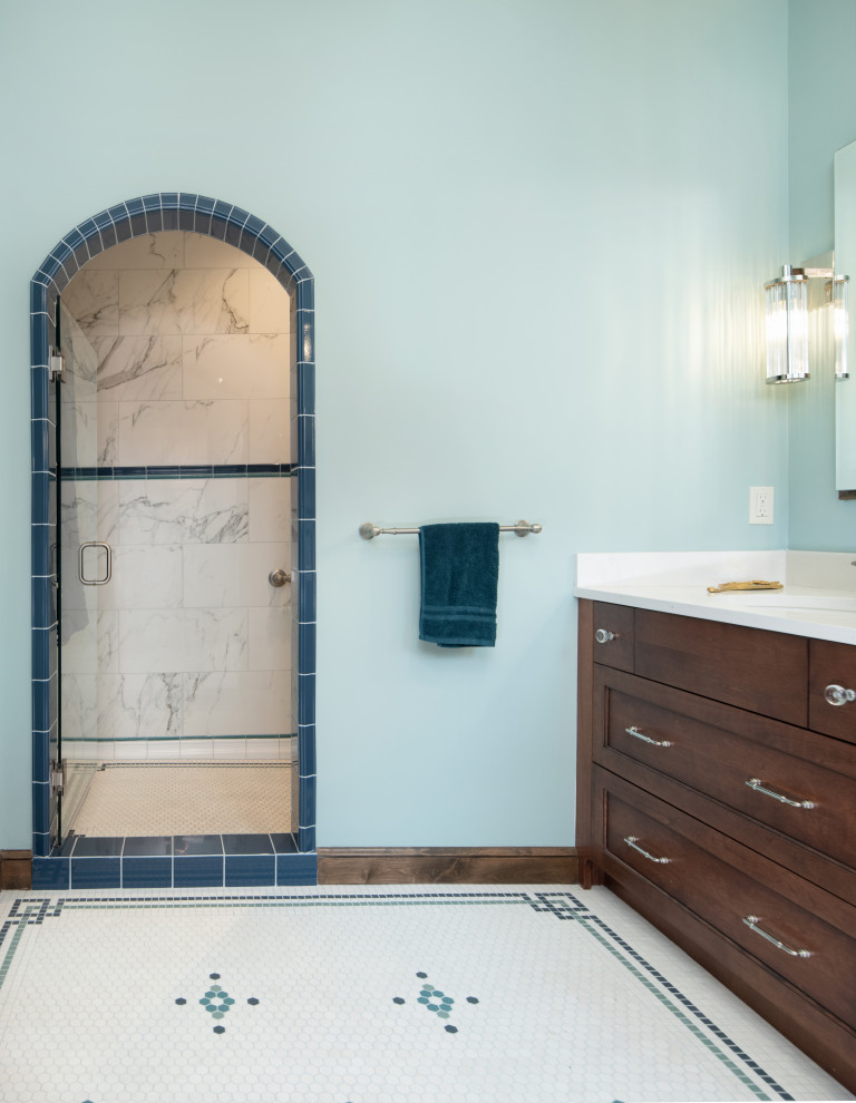 Aménagement d'une salle de bain classique en bois brun avec un placard à porte shaker, une douche double, un carrelage blanc, des carreaux de porcelaine, un mur bleu, un sol en carrelage de terre cuite, un plan de toilette en quartz modifié, un sol blanc, un plan de toilette blanc, meuble double vasque et meuble-lavabo encastré.
