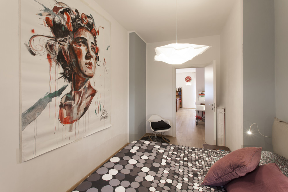 Mid-sized contemporary master bedroom in Turin with multi-coloured walls and medium hardwood floors.