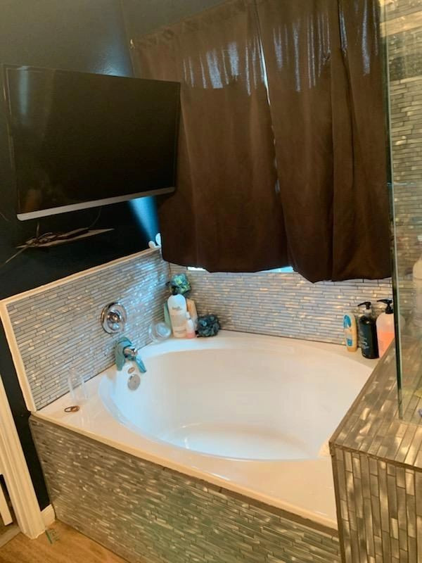 Bild på ett litet vintage en-suite badrum, med släta luckor, ett platsbyggt badkar, en öppen dusch, en toalettstol med hel cisternkåpa, blå kakel, glaskakel, bruna väggar, vinylgolv, brunt golv och med dusch som är öppen