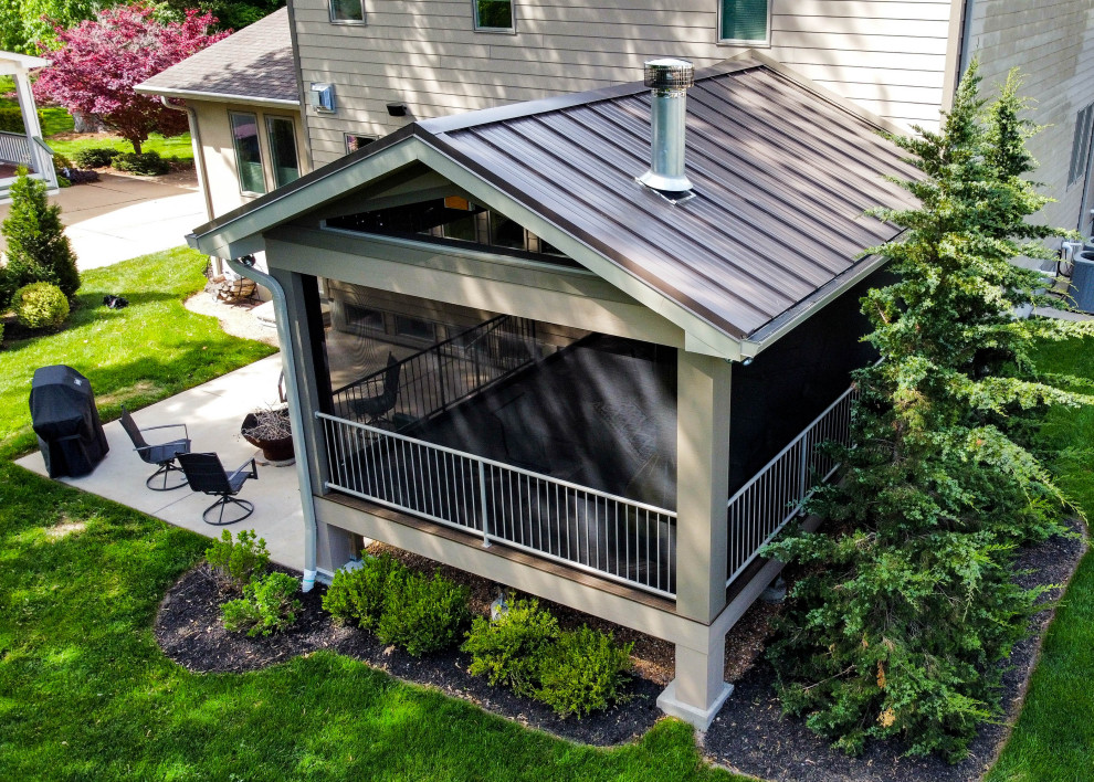 Réalisation d'une terrasse arrière et au rez-de-chaussée vintage de taille moyenne avec des solutions pour vis-à-vis, une extension de toiture et un garde-corps en métal.