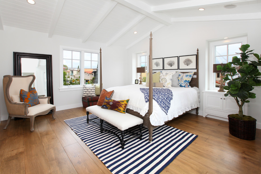 Photo of a beach style bedroom in Orange County with white walls, medium hardwood floors and no fireplace.