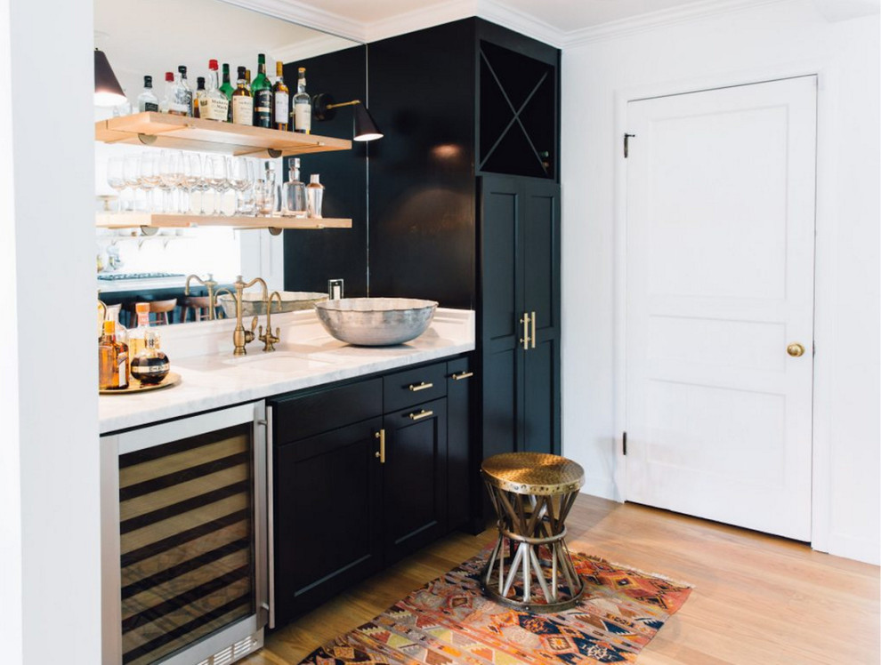 Photo of a mid-sized transitional single-wall wet bar in San Francisco with an undermount sink, recessed-panel cabinets, black cabinets, quartzite benchtops, mirror splashback and light hardwood floors.