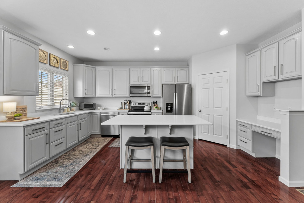 Transitional dark wood floor eat-in kitchen photo with a double-bowl sink, gray cabinets, quartz countertops, stainless steel appliances, an island and white countertops