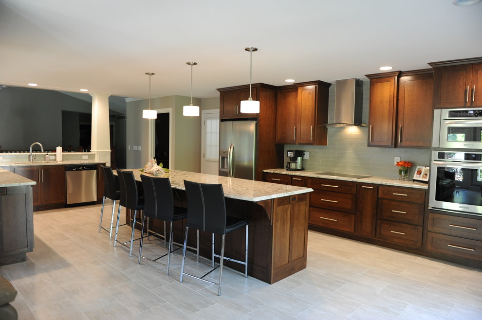 Huge transitional u-shaped ceramic tile open concept kitchen photo in Chicago with an undermount sink, shaker cabinets, medium tone wood cabinets, granite countertops, gray backsplash, glass tile backsplash, stainless steel appliances and an island