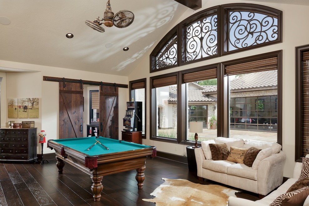 Inspiration for a large mediterranean enclosed family room in Houston with a game room, dark hardwood floors and no fireplace.