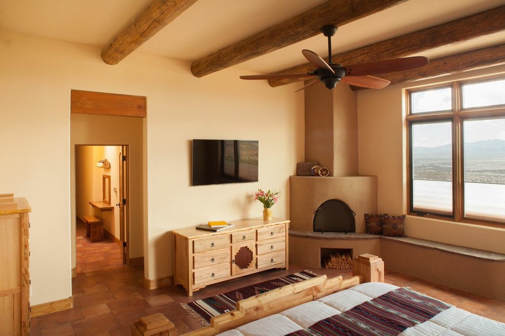 This is an example of a bedroom in Albuquerque with beige walls, ceramic floors and a corner fireplace.