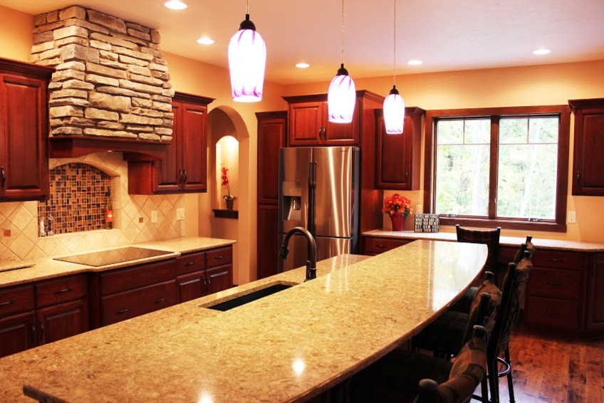 Eat-in kitchen - large galley medium tone wood floor eat-in kitchen idea with an undermount sink, raised-panel cabinets, medium tone wood cabinets, quartz countertops, beige backsplash, ceramic backsplash, stainless steel appliances and an island