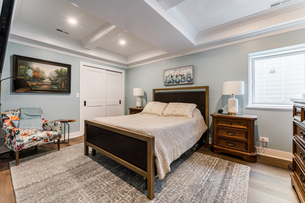 Cette image montre une chambre d'amis traditionnelle de taille moyenne avec un mur bleu, un sol en vinyl, aucune cheminée, un sol marron et un plafond à caissons.