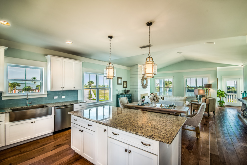 Eat-in kitchen - mid-sized transitional l-shaped medium tone wood floor eat-in kitchen idea in Jacksonville with a farmhouse sink, shaker cabinets, white cabinets, glass countertops, blue backsplash, ceramic backsplash, stainless steel appliances and an island
