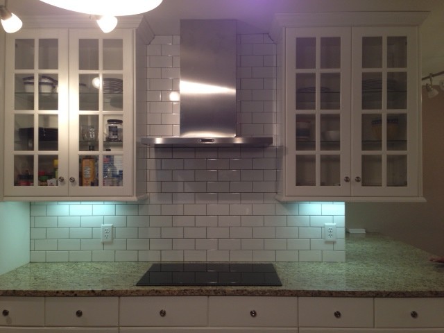 Example of a transitional kitchen design in Chicago with glass-front cabinets, white cabinets, granite countertops, white backsplash and subway tile backsplash