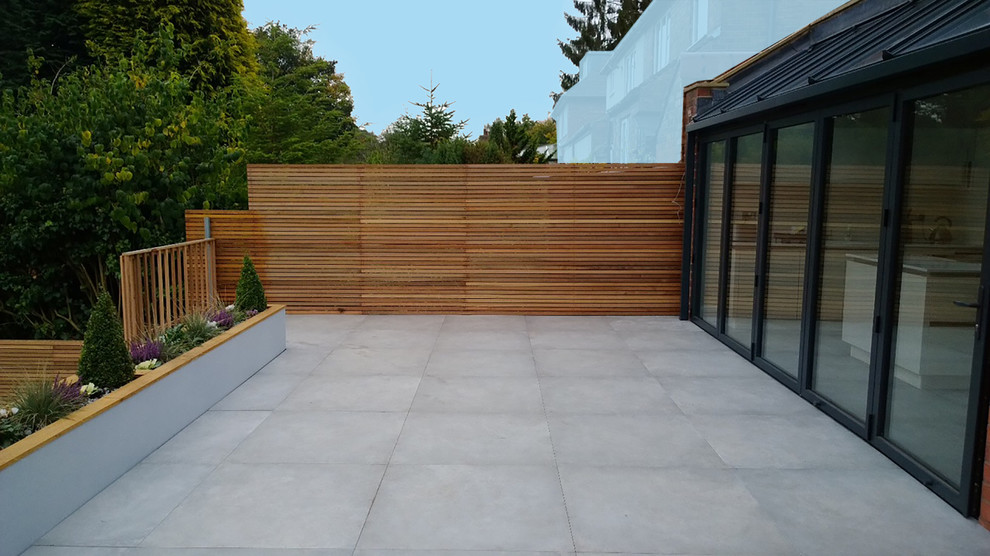 This is an example of a contemporary backyard patio in West Midlands with tile.