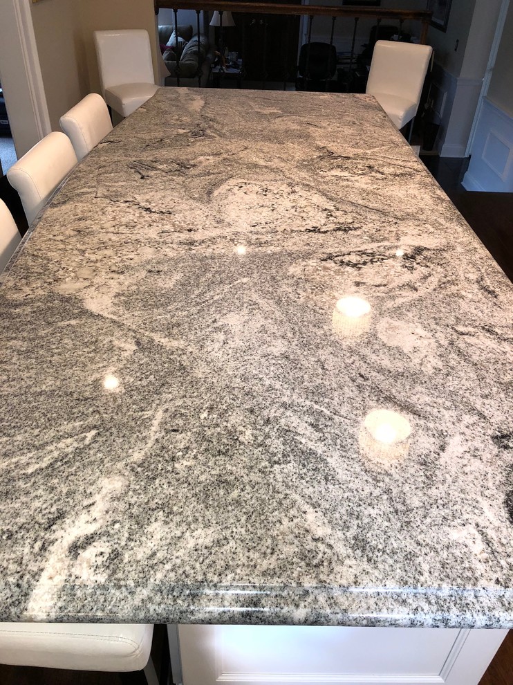 Inspiration for a large transitional l-shaped medium tone wood floor and brown floor eat-in kitchen remodel in New York with a double-bowl sink, shaker cabinets, white cabinets, quartzite countertops, beige backsplash, stainless steel appliances, an island and black countertops