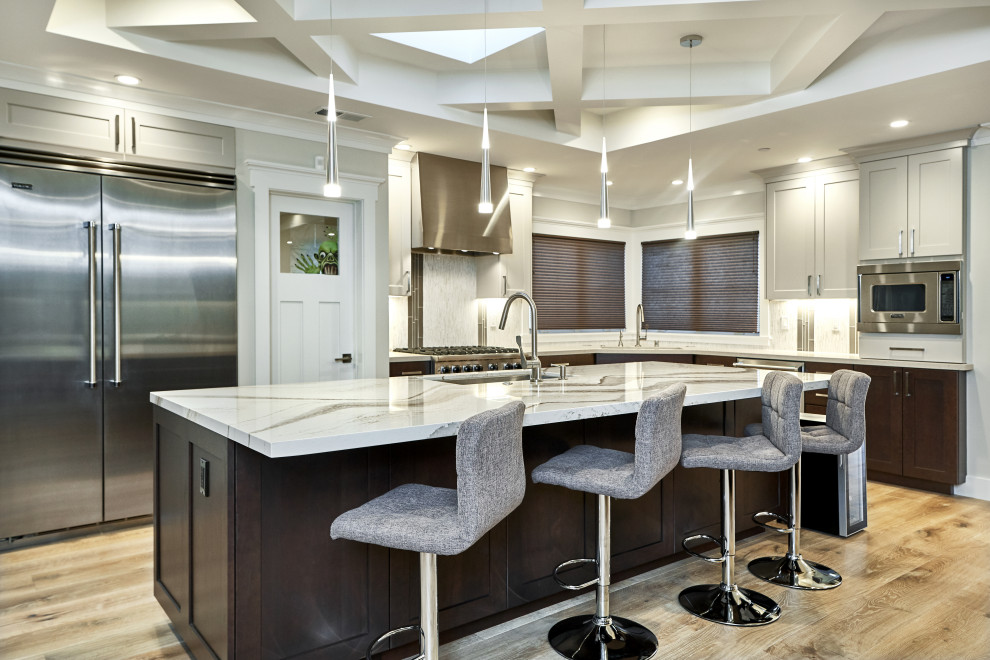 Inspiration for a transitional l-shaped kitchen in San Francisco with an undermount sink, shaker cabinets, beige cabinets, grey splashback, matchstick tile splashback, stainless steel appliances, medium hardwood floors, with island, brown floor and grey benchtop.