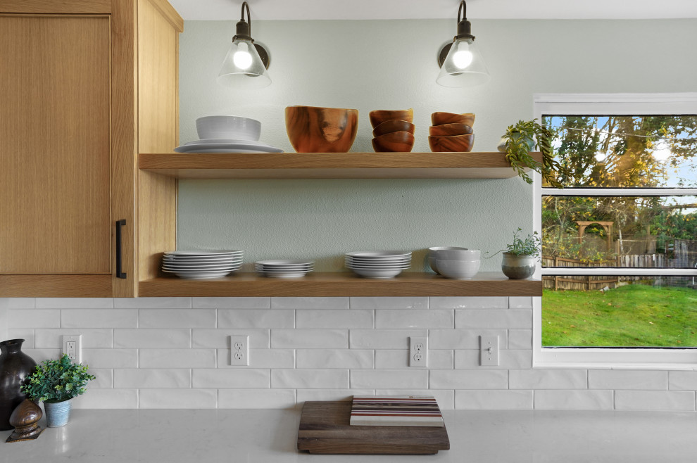 Photo of an expansive eclectic l-shaped kitchen/diner in Other with a submerged sink, shaker cabinets, light wood cabinets, engineered stone countertops, white splashback, metro tiled splashback, stainless steel appliances, medium hardwood flooring, no island and white worktops.