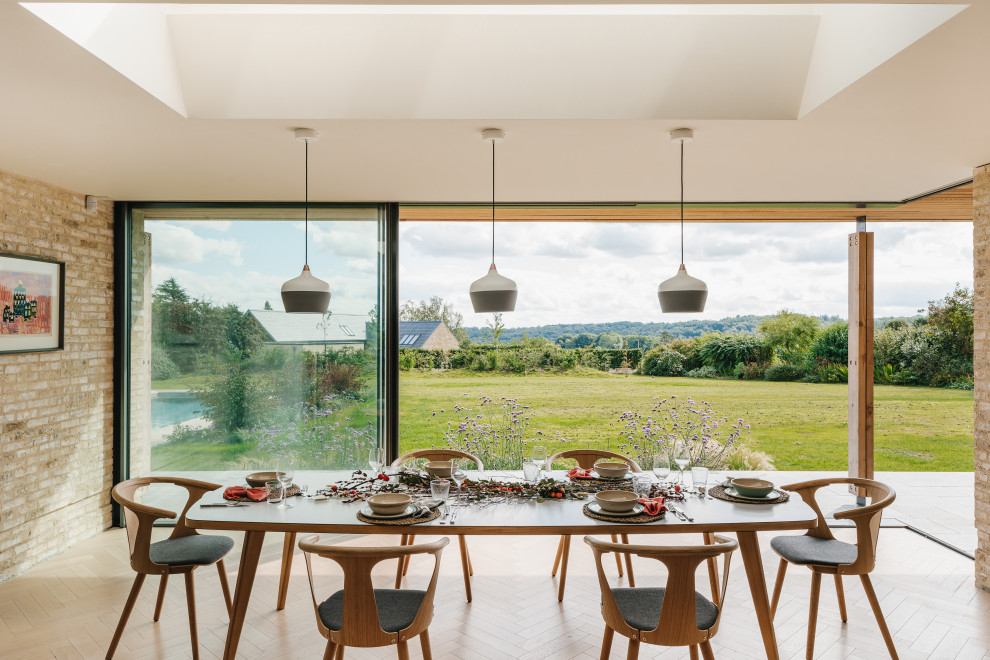Contemporary dining room in Wiltshire with beige walls, light hardwood flooring, beige floors and a vaulted ceiling.