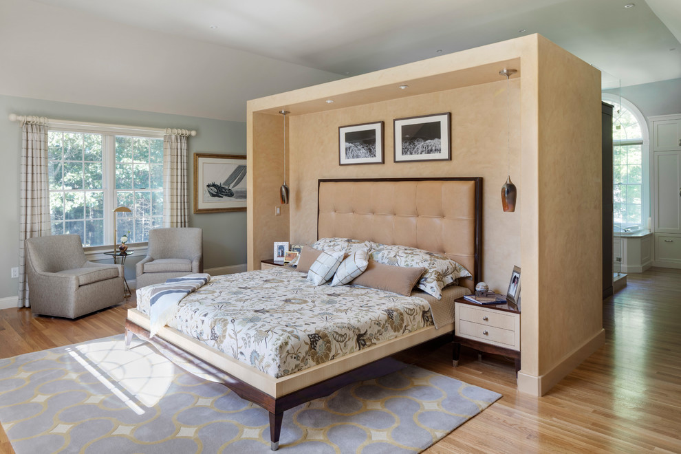 Photo of a large transitional master bedroom in Boston with blue walls and medium hardwood floors.