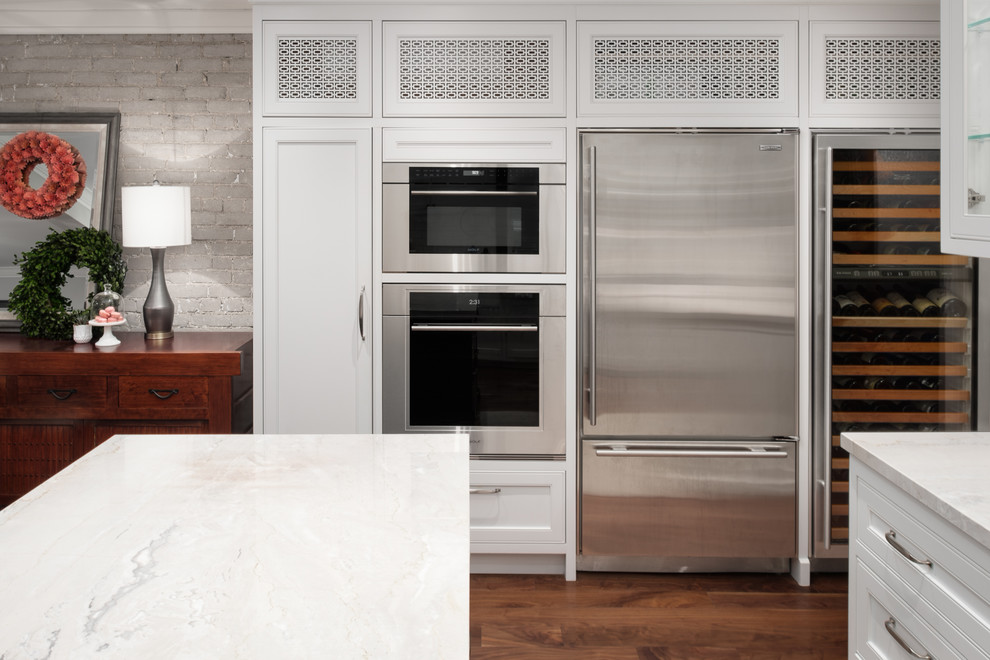 Mid-sized transitional u-shaped medium tone wood floor and brown floor eat-in kitchen photo in Toronto with a farmhouse sink, recessed-panel cabinets, gray cabinets, quartzite countertops, white backsplash, subway tile backsplash, stainless steel appliances, an island and beige countertops
