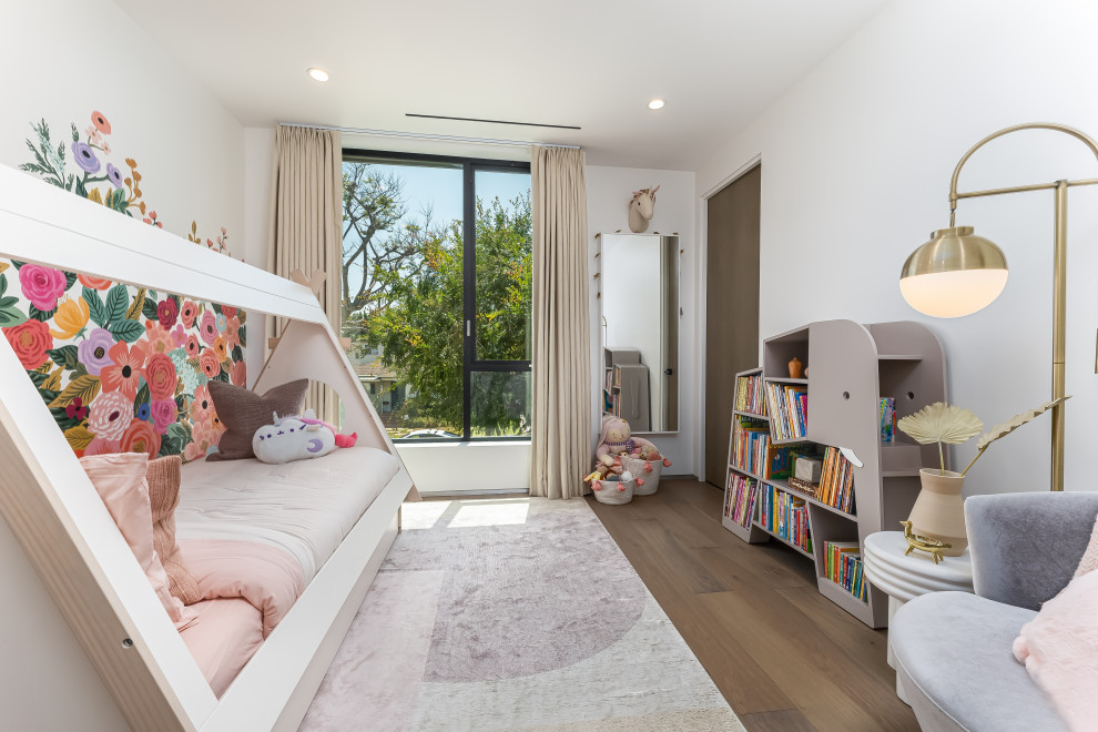 Inspiration for a mid-sized contemporary girl medium tone wood floor and brown floor kids' room remodel in Los Angeles with multicolored walls