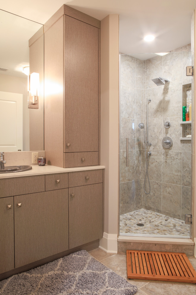 Photo of a mid-sized contemporary 3/4 bathroom in New York with flat-panel cabinets, light wood cabinets, a corner shower, a two-piece toilet, porcelain tile, beige walls, porcelain floors, a drop-in sink and engineered quartz benchtops.