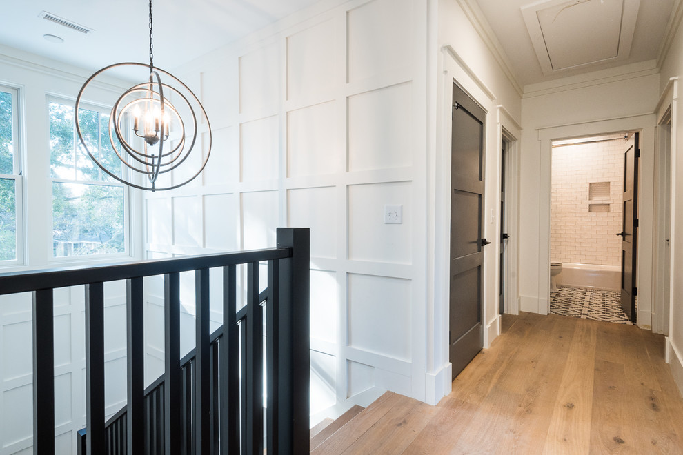 Design ideas for a large modern hallway in Charleston with white walls, light hardwood floors and brown floor.