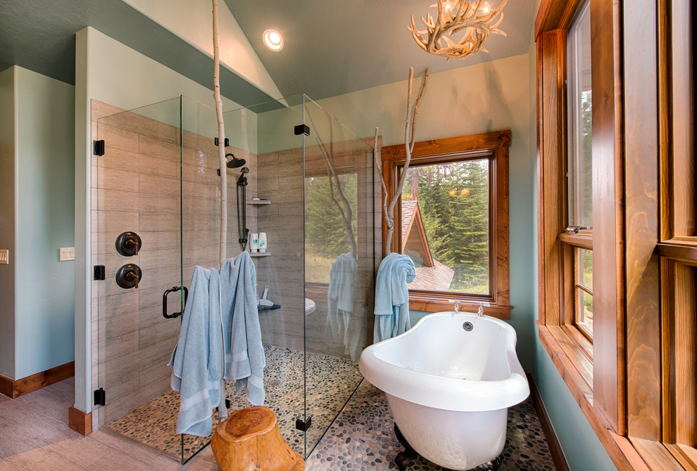 Photo of a country bathroom in Boise with a claw-foot tub, a corner shower, gray tile and grey walls.