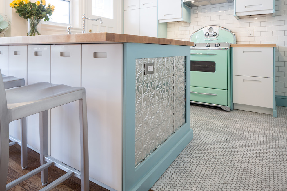 Example of a small transitional l-shaped marble floor eat-in kitchen design in Toronto with a farmhouse sink, flat-panel cabinets, white cabinets, wood countertops, white backsplash, subway tile backsplash, colored appliances and a peninsula