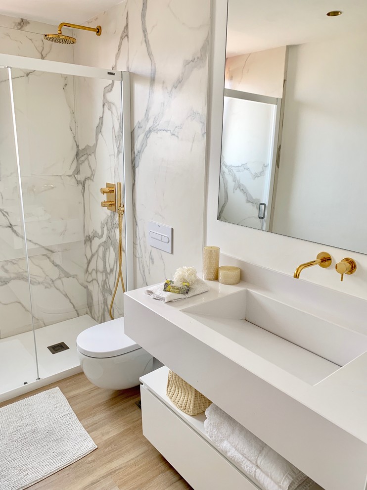 Inspiration for a mid-sized modern 3/4 bathroom in Other with recessed-panel cabinets, white cabinets, a wall-mount toilet, white walls, light hardwood floors, a wall-mount sink, brown floor, a sliding shower screen, white benchtops and an alcove shower.