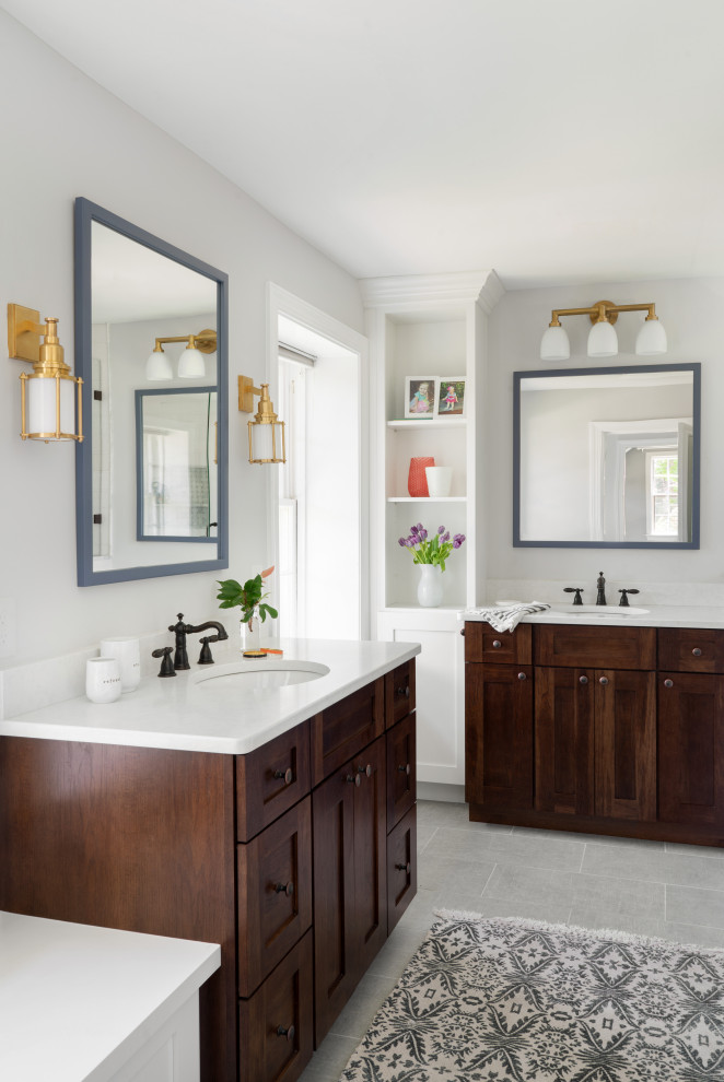 This is an example of a transitional bathroom in Philadelphia with shaker cabinets, dark wood cabinets, grey walls, an undermount sink, grey floor and white benchtops.