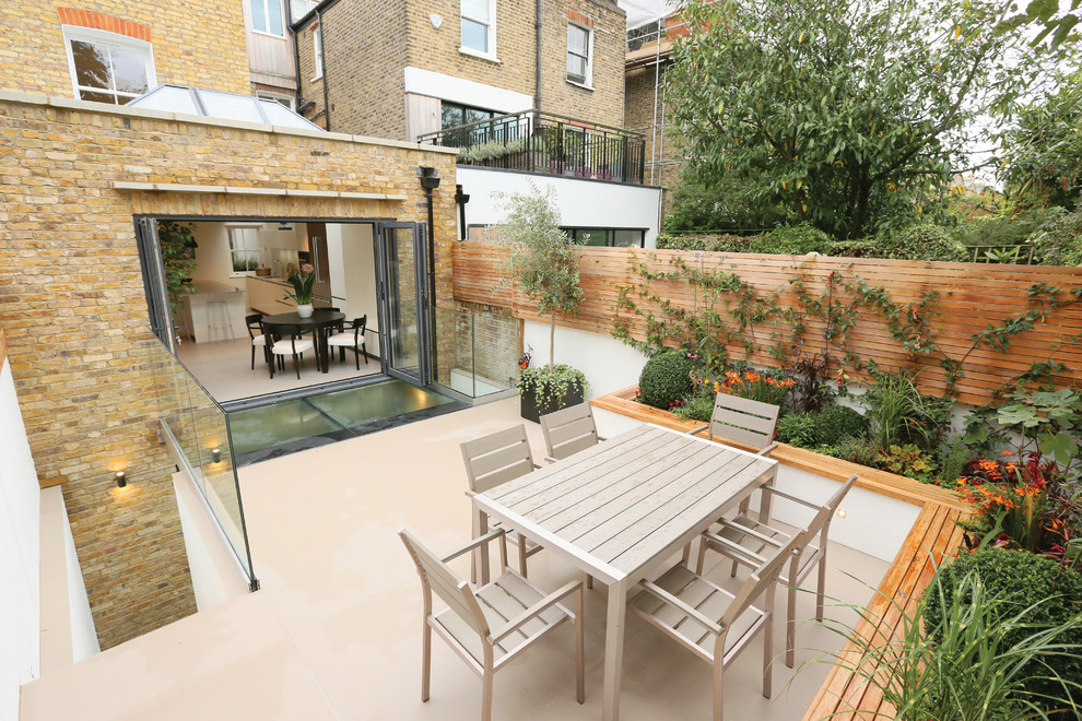Inspiration for a small contemporary backyard patio in London with a container garden and no cover.