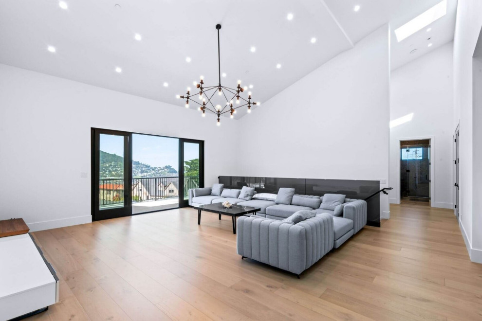 Vaulted Family Room with Hillside Views and Modern Chandelier