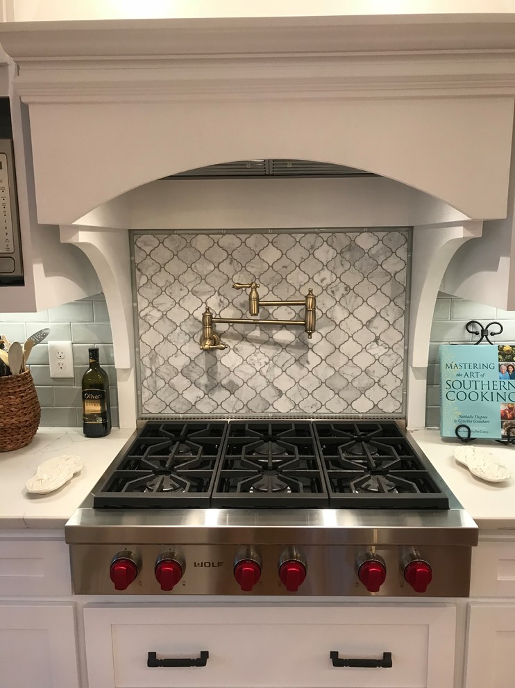 Eat-in kitchen - mid-sized transitional u-shaped medium tone wood floor and brown floor eat-in kitchen idea in Atlanta with a farmhouse sink, shaker cabinets, white cabinets, subway tile backsplash, stainless steel appliances, an island and granite countertops