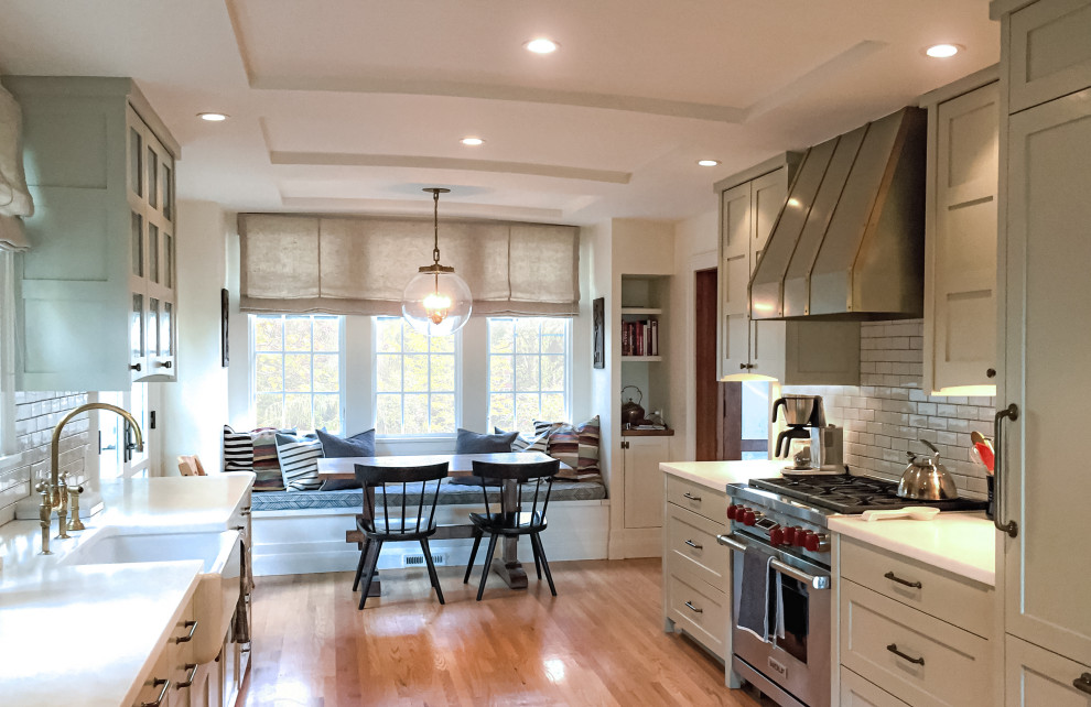 Imagen de cocina de estilo americano con salpicadero de azulejos tipo metro y suelo de madera en tonos medios