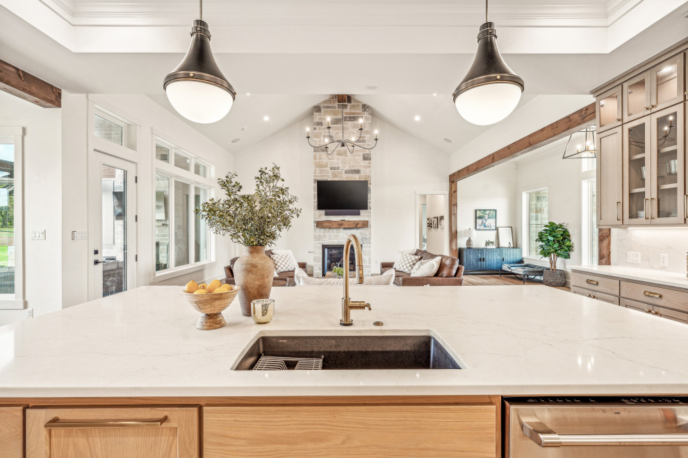 Inspiration for a mid-sized transitional l-shaped vinyl floor and tray ceiling eat-in kitchen remodel in Dallas with an undermount sink, shaker cabinets, light wood cabinets, quartz countertops, white backsplash, quartz backsplash, stainless steel appliances, an island and white countertops