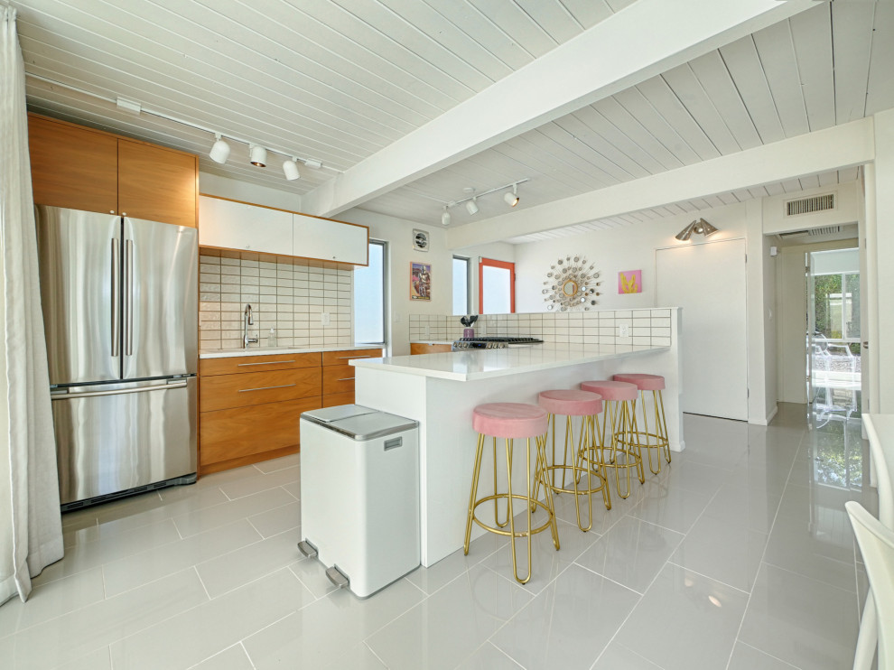 Design ideas for a small retro u-shaped kitchen/diner in Other with a built-in sink, medium wood cabinets, white splashback, ceramic splashback, stainless steel appliances, porcelain flooring, an island, grey floors, white worktops and a wood ceiling.
