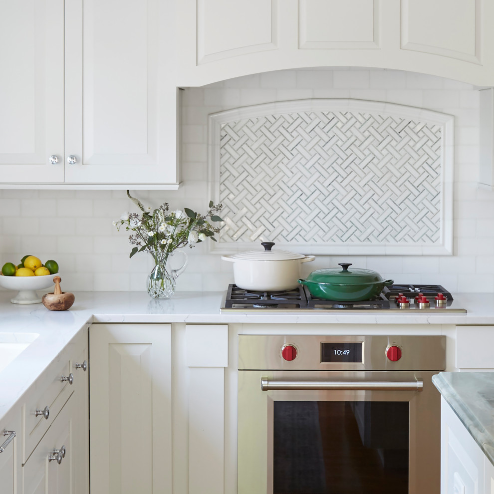 Inspiration for a large traditional l-shaped eat-in kitchen in Chicago with an undermount sink, raised-panel cabinets, white cabinets, quartzite benchtops, white splashback, mosaic tile splashback, stainless steel appliances, medium hardwood floors, with island, brown floor and blue benchtop.