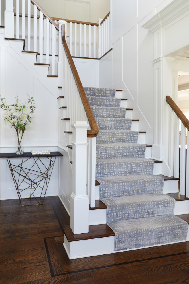 Design ideas for a transitional carpeted l-shaped staircase in New York with wood railing.