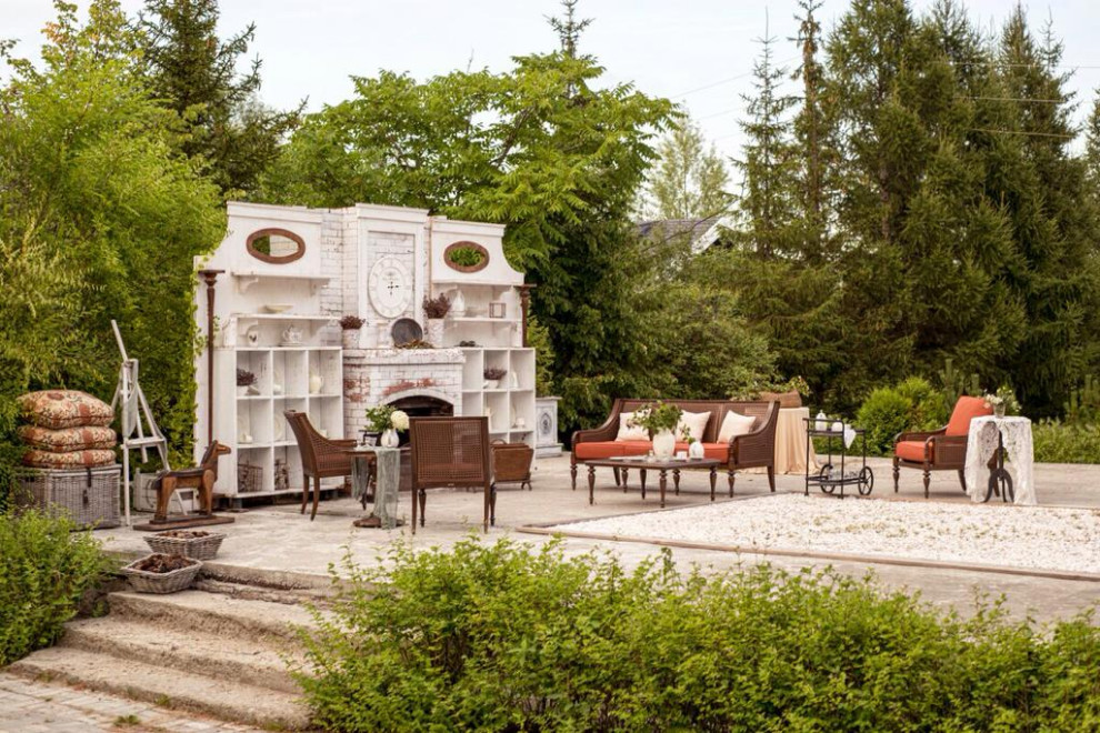 This is an example of a large traditional backyard patio in Moscow with with fireplace.