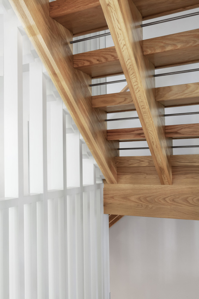 This is an example of a mid-sized scandinavian wood l-shaped staircase in Indianapolis with open risers and wood railing.