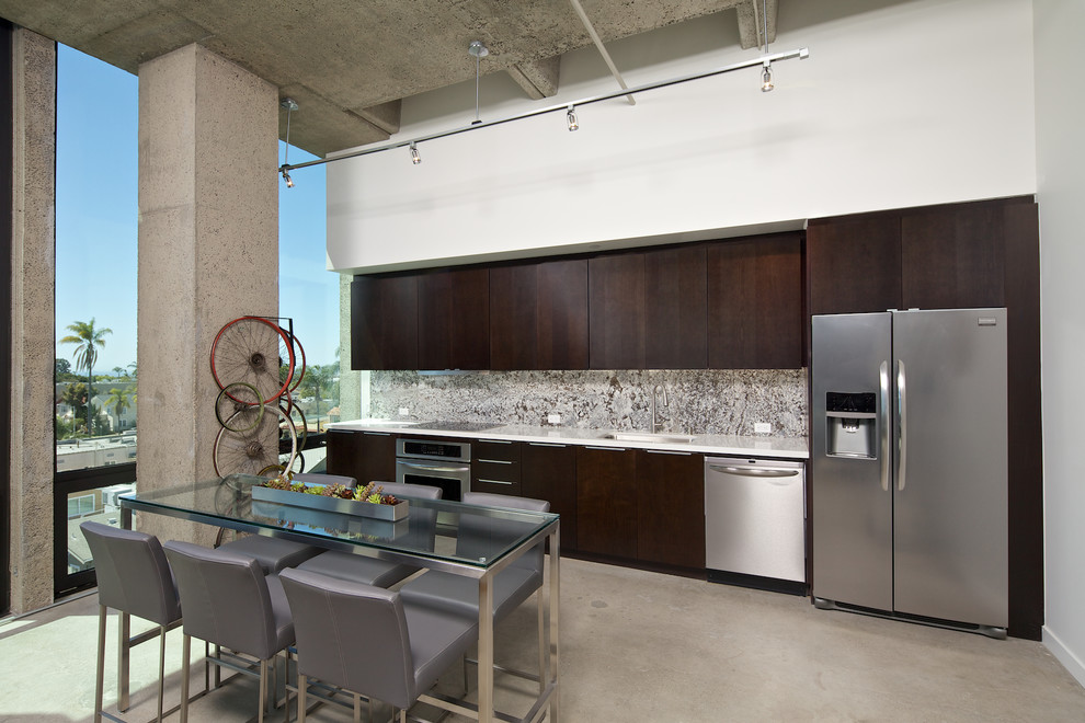 Inspiration for an industrial single-wall eat-in kitchen in San Diego with an undermount sink, flat-panel cabinets, dark wood cabinets, multi-coloured splashback, stainless steel appliances, concrete floors and no island.
