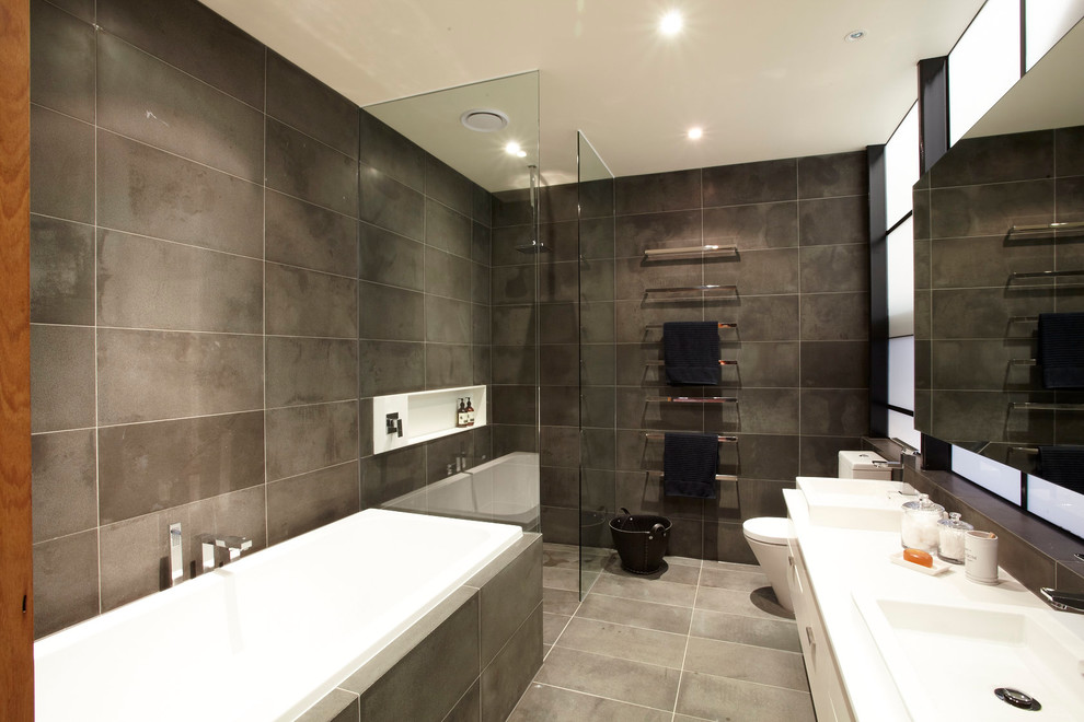 Design ideas for an industrial bathroom in Melbourne with a drop-in sink, white cabinets, a drop-in tub, a corner shower, gray tile and white benchtops.