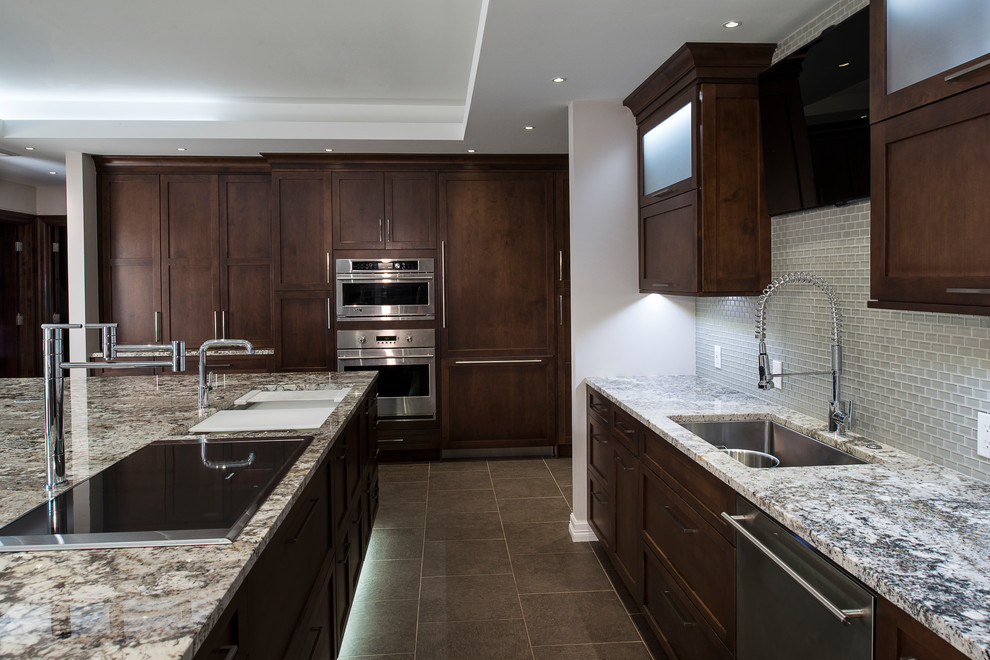 Eat-in kitchen - large transitional ceramic tile and beige floor eat-in kitchen idea with an undermount sink, shaker cabinets, brown cabinets, granite countertops, white backsplash, glass tile backsplash, stainless steel appliances and an island