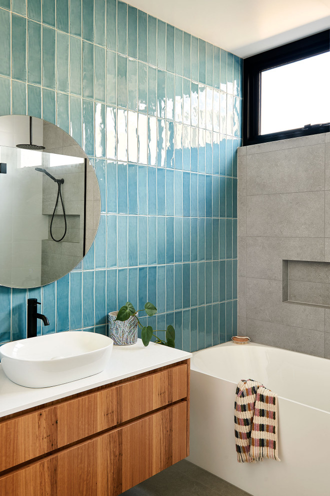 Photo of a large nautical ensuite bathroom in Geelong with flat-panel cabinets, light wood cabinets, a walk-in shower, blue tiles, ceramic tiles, porcelain flooring, a pedestal sink, engineered stone worktops, grey floors, an open shower, white worktops and a freestanding vanity unit.