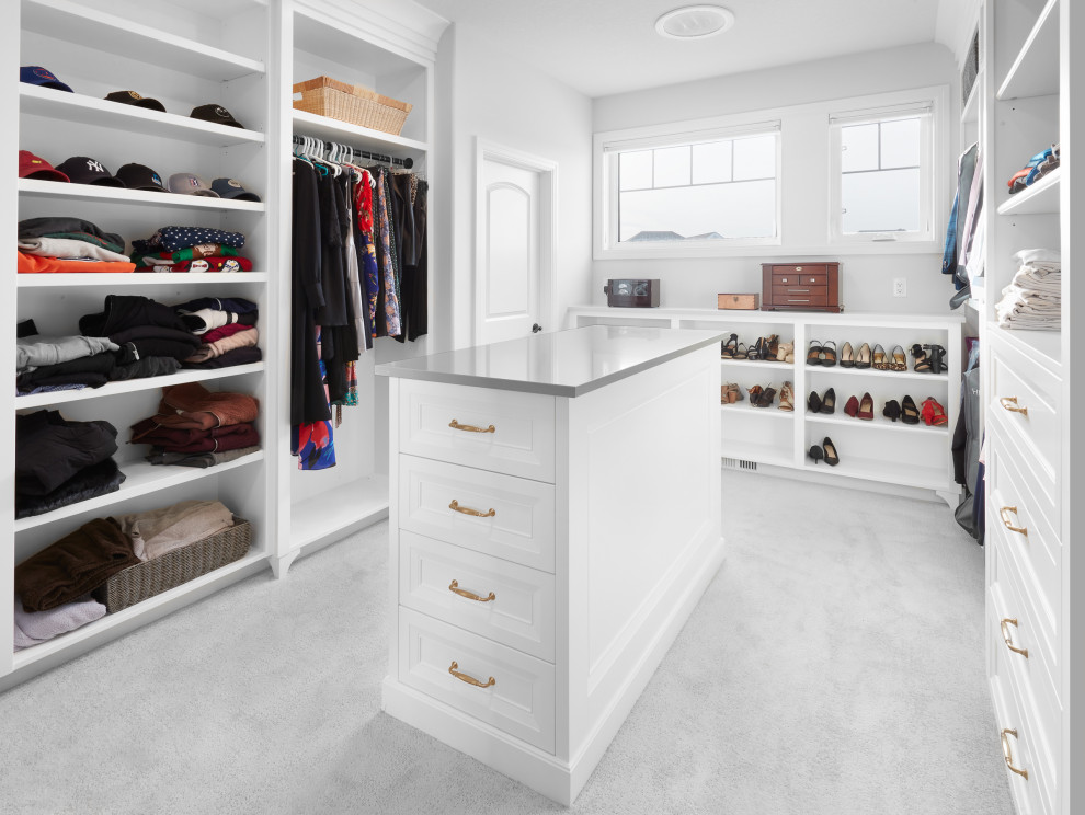 Diseño de armario vestidor unisex clásico renovado de tamaño medio con armarios con rebordes decorativos, puertas de armario blancas y moqueta