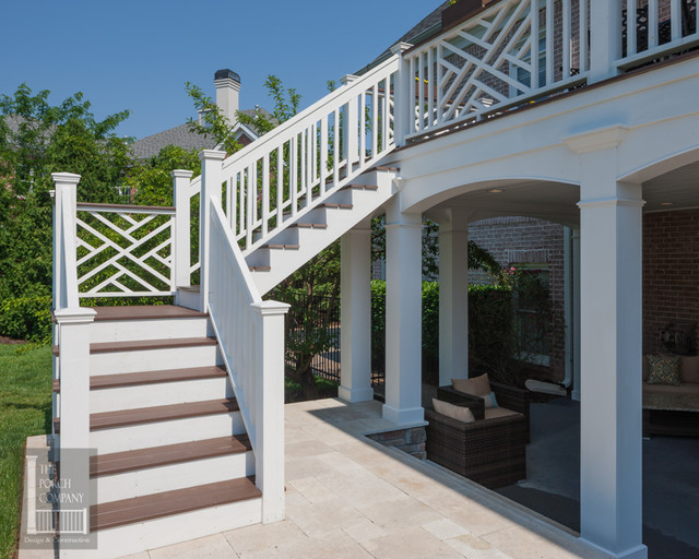 Two story double porch with outdoor fireplace, travertine patio, and