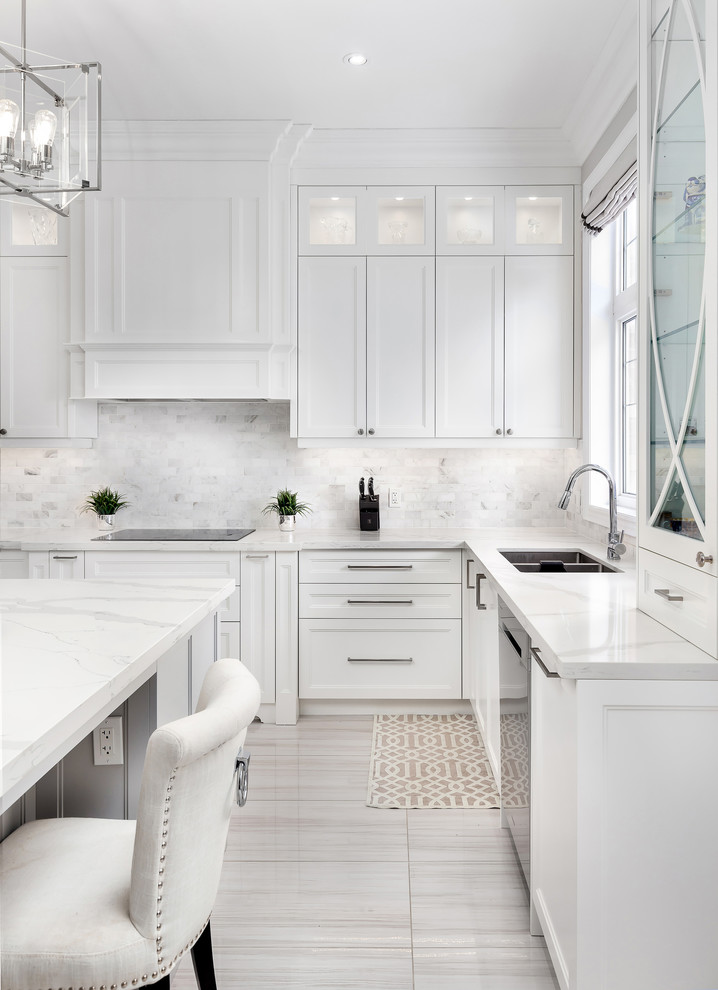 Inspiration for a large transitional u-shaped open plan kitchen in Toronto with an undermount sink, shaker cabinets, white cabinets, quartz benchtops, grey splashback, mosaic tile splashback, stainless steel appliances, ceramic floors, with island, grey floor and white benchtop.