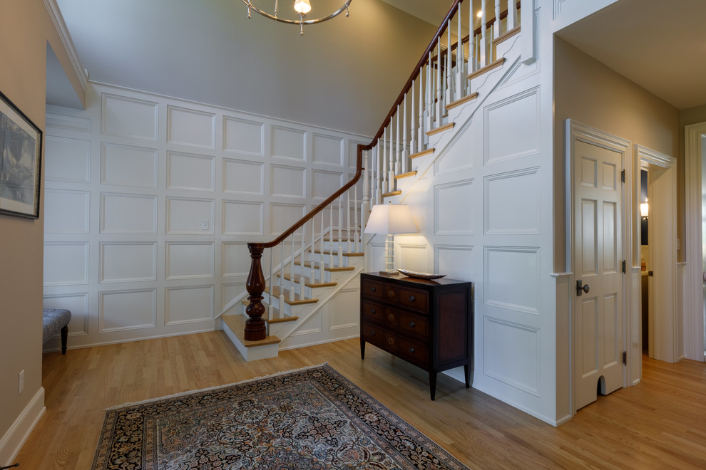 Photo of a large traditional foyer in Other with light hardwood floors, grey walls and a dark wood front door.