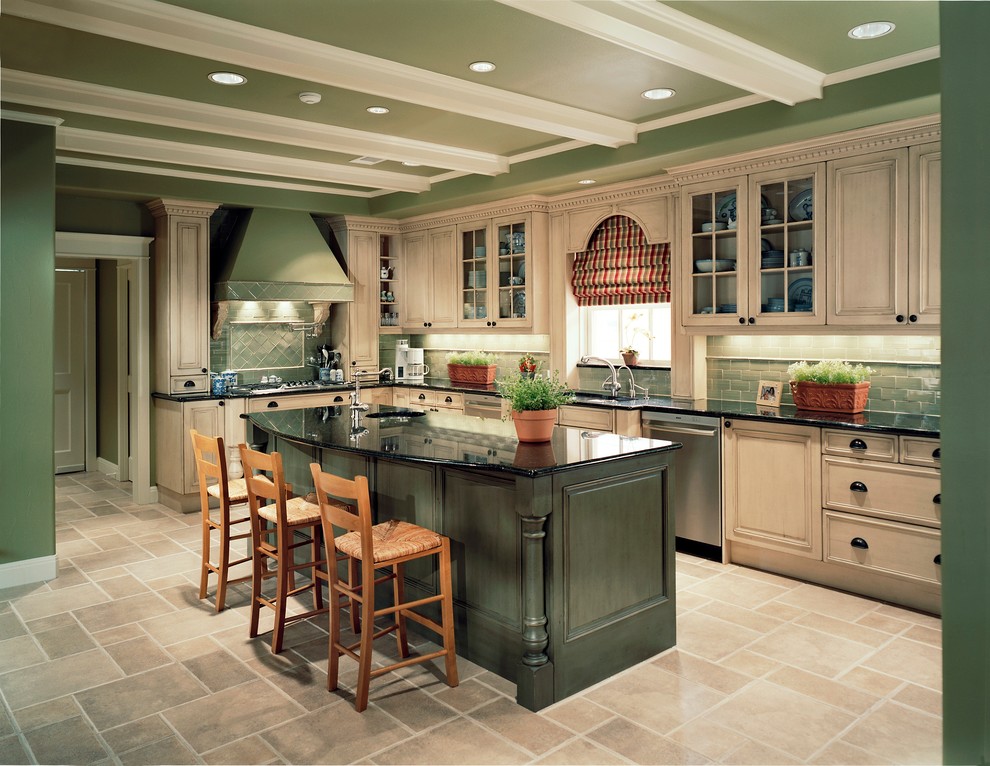 Inspiration for a mid-sized traditional l-shaped eat-in kitchen in Dallas with recessed-panel cabinets, beige cabinets, green splashback, subway tile splashback, stainless steel appliances, travertine floors and with island.
