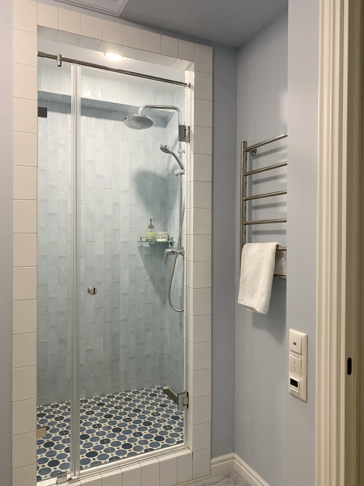 Пример оригинального дизайна: ванная комната среднего размера в стиле неоклассика (современная классика) с фасадами с утопленной филенкой, белыми фасадами, душем в нише, инсталляцией, синей плиткой, керамической плиткой, синими стенами, полом из керамогранита, душевой кабиной, подвесной раковиной, разноцветным полом, душем с распашными дверями, гигиеническим душем, тумбой под одну раковину и подвесной тумбой